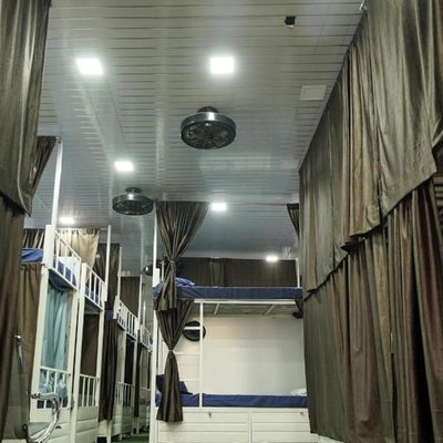 Air-conditioned dormitory at Zest Stays 1054 with ceiling fans and LED panel lighting